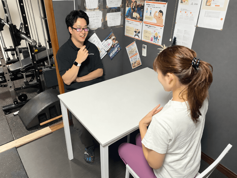 ジムでトレーニング中に会話する様子